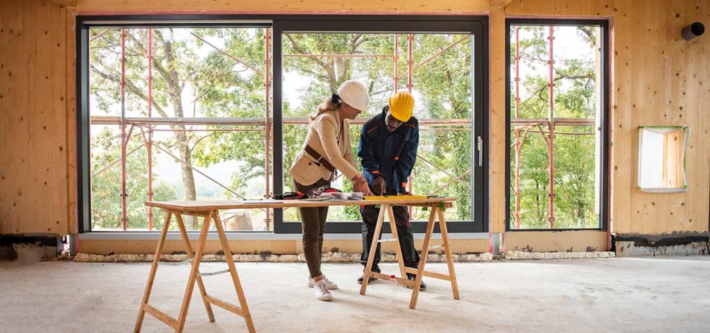 Two construction workers discussing plans for a new construction home build