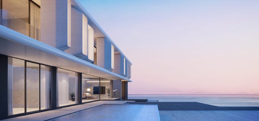 Exterior shot of a two-story modern home at dusk with luxury floor-to-ceiling windows and an expansive outdoor area and infinity pool
